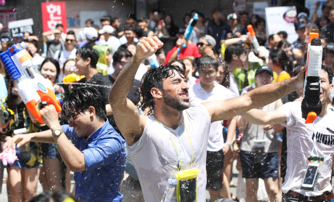 Crowds soaked in water gun fight on Yonsei-ro at the Sinchon Water Gun Festival in Seoul