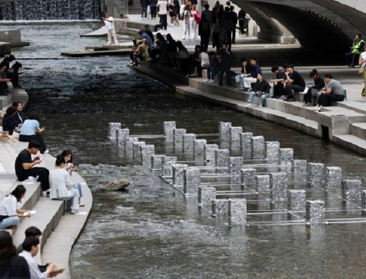 People relax along Cheonggyecheon stream in central Seoul, the symbol of the city's post-industrial green infrastructure pivot