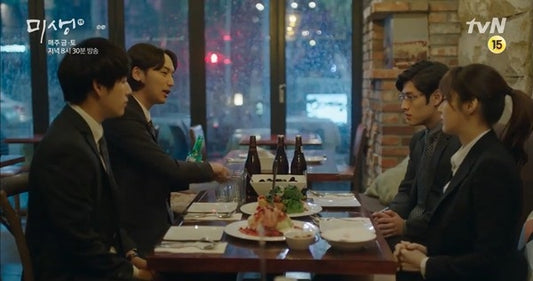 Office workers gathered around a hweshik table in a scene from the Korean workplace drama Misaeng on tvN
