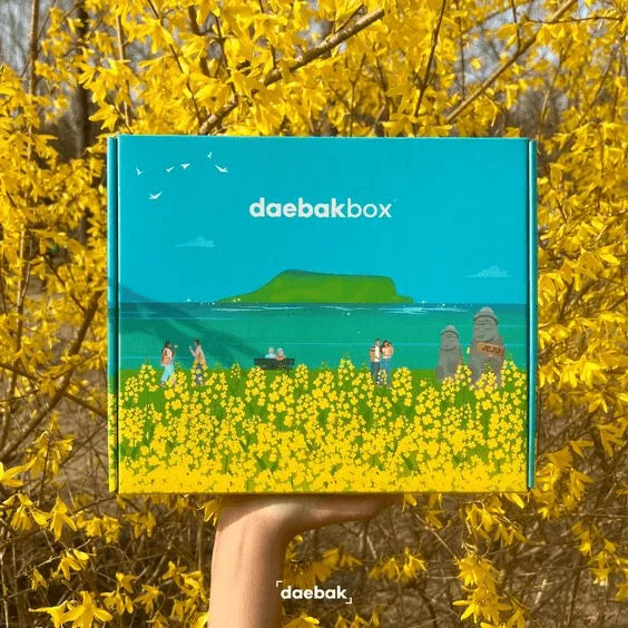Daebak Spring Box featuring a curated selection of Korean beauty, fashion, snacks, and lifestyle items in bright, seasonal packaging.